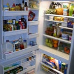 An Open refrigerator with food on the shelves and door.