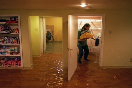 A Basement that flooded after a thunderstorm left the sump pump without power. Homeowner is standing in water while salvaging what he can.
