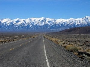 Highway 50 in Nevada appears to end at the base of snow-capped mountains.