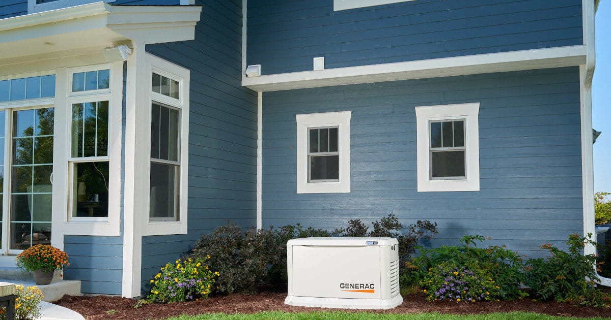 A 22kW Generac Installed Outside a Large Two-Story Blue Home with White Trim