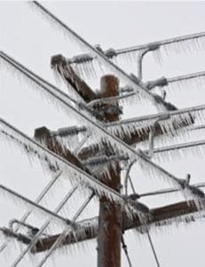 Power Lines Coated with Ice and Icicles meet at a Utility Pole from Different Directions