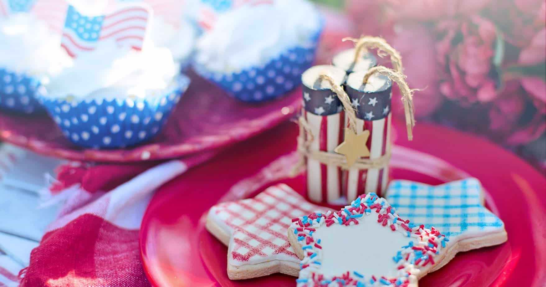 Cookies and Cupcakes decorated for the 4th of July Picnic with a centerpiece made of star-spangled faux firecrackers with long hemp wicks.
