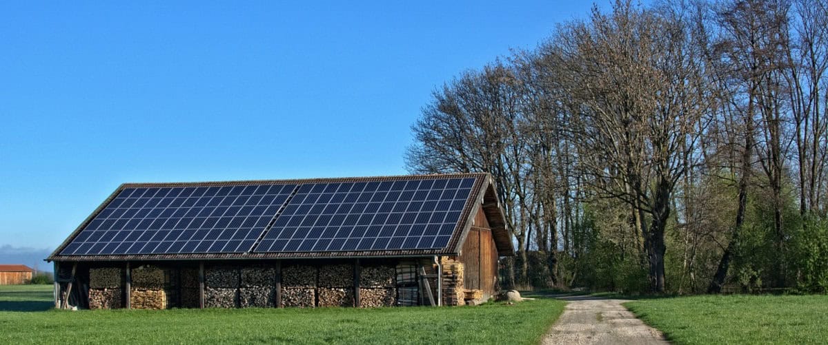 An Off Grid Home with Solar Panels for electricity and wood stacked for heat and cooking.