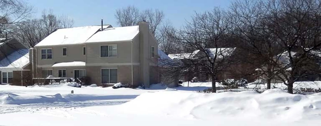 A neighborhood is blanketed with snow after a winter storm. Conspicuously absent is smoke from any chimney because no one has power.